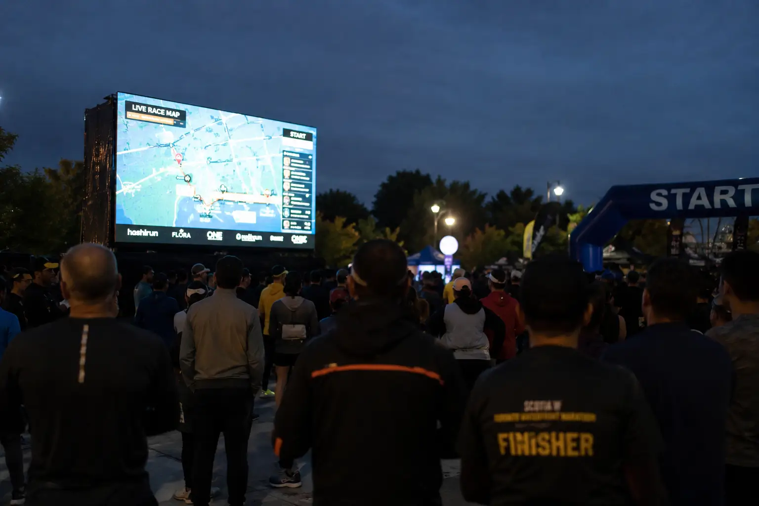 A crowd watching the hashiRun Live Race Wall at an event
