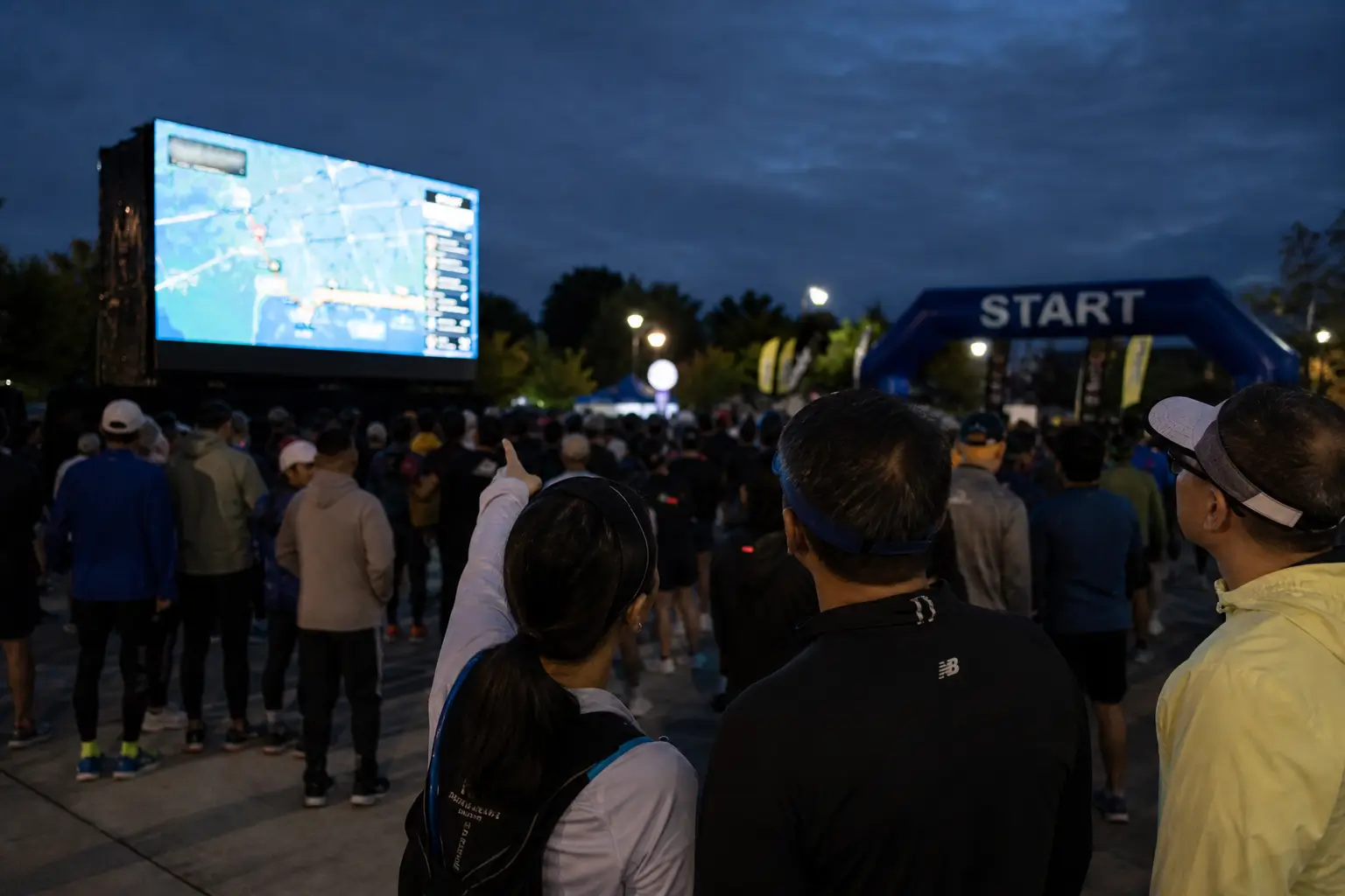 Spectators pointing toward runners on the Live Race Wall